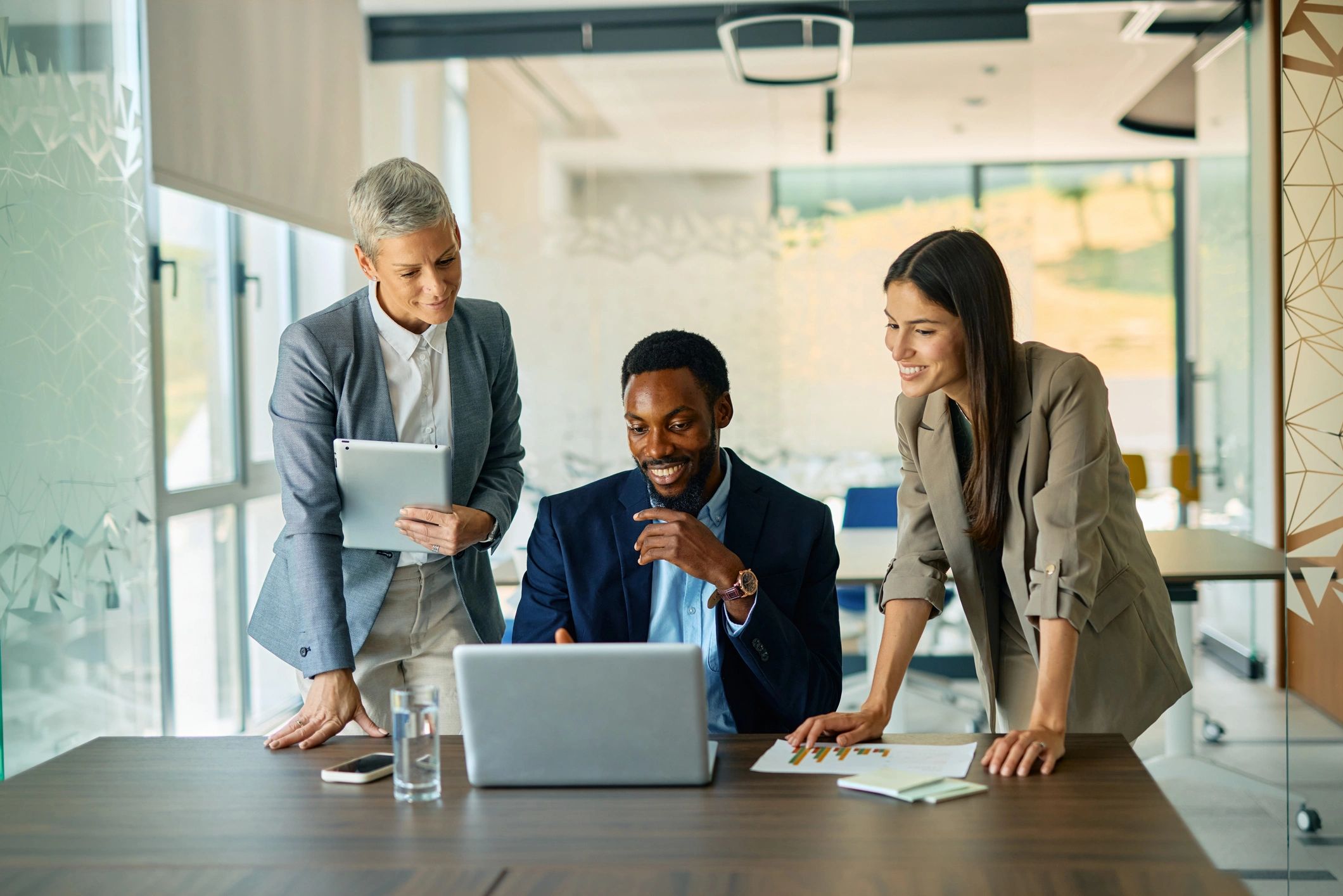 Business team collaborating on a laptop in a modern office