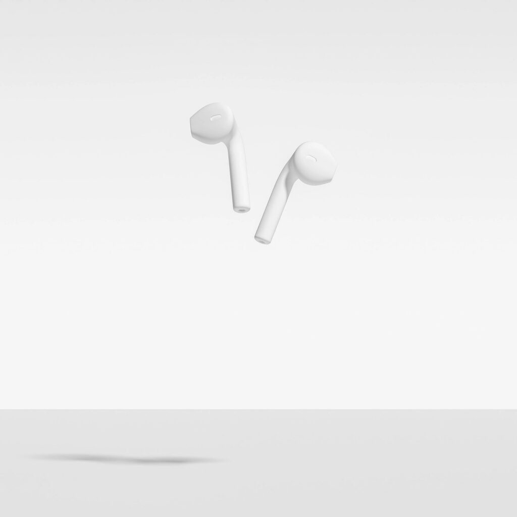 In Ear Headphones Isolated On White Background. Abstract Image of White Painted earphones, Falling, Floating, Suspended, Isolated Against White